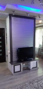 TV de pantalla plana grande en la sala de estar. en Квартира в центре города на Арбате, en Almaty