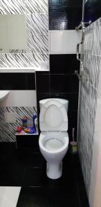 a bathroom with a toilet in a black and white bathroom at Арбат in Almaty