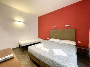 um quarto com uma cama e uma parede vermelha em Veneto Boutique Suites em Roma