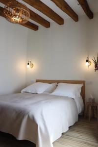 um quarto com uma cama branca e um lustre em La Petite Boire - Chambres d'hôtes em Mûrs-Érigné