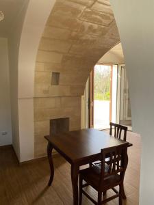 un tavolo in legno e 2 sedie in una stanza di Uliveto Sant' Isidoro a Maglie