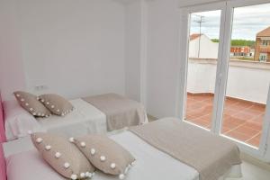 two beds in a room with a window at Villa Conce in La Bañeza
