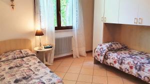 1 dormitorio con 2 camas, mesa y ventana en APARTMENT A CASA DI LA' - Regarda Travel en Lazise