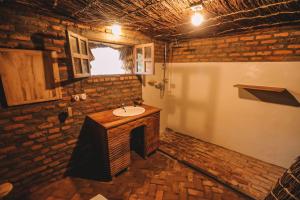a bathroom with a sink in a brick wall at Sextantio Rwanda, The Capanne (Huts) Project in Kamembe