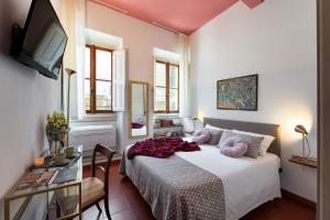 フィレンツェにあるPitti - Flo Apartmentsのベッドルーム(ベッド1台、テーブル、テレビ付)