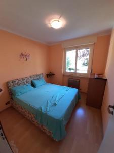 een slaapkamer met een blauw bed en een raam bij Lovely 1bedroom apartment central valley location in Aosta