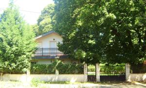 uma casa branca com cerca e árvores em 3 bedrooms house with enclosed garden and wifi at O Savinao 3 km away from the beach em Licín