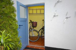 ヴァーネミュンデにあるFerienhaus der kurzen Wege Objekt 40105のドアの隣に2台の自転車が停まっています。