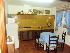 a kitchen with a table and chairs and a refrigerator at 3 bedrooms house with enclosed garden and wifi at O Savinao 3 km away from the beach in Licín