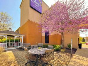 a patio with a table and chairs in front of a building at Sleep Inn near Penn State - State College in State College