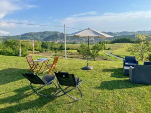 a couple of chairs and an umbrella on the grass at Vista sul Forte in Gavi