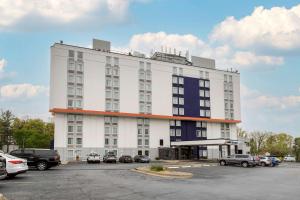 un edificio blanco con coches estacionados en un estacionamiento en Comfort Inn & Suites Alexandria West, en Alexandria