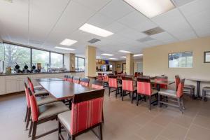 a dining room with red chairs and a long table at Comfort Inn & Suites Alexandria West in Alexandria