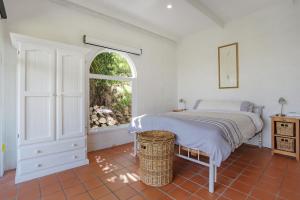 a bedroom with a bed and an open window at Cordova - Perfect Summer or Winter Getaway in Merimbula