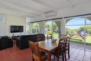 a living room with a table and chairs and a couch at Cordova - Perfect Summer or Winter Getaway in Merimbula
