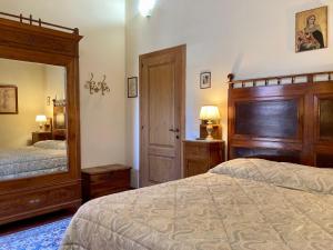 1 Schlafzimmer mit 2 Betten und einem großen Spiegel in der Unterkunft Monteriggioni Castello in Monteriggioni