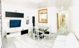 a living room with a table and a television at Precioso apartamento cerca del mar con wifi, piscina y parking in La Herradura