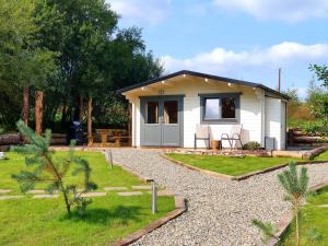a small white house with a gravel yard at The Oaks Luxury Lodges in Drumahoe