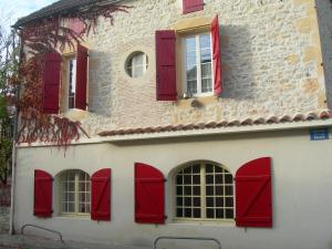 a building with red shuttered windows on it at Appartement indépendant au coeur du Vignoble in Prayssac