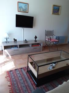 - un salon avec une télévision et une table basse dans l'établissement Gite La RESTANCO, à Mouriès