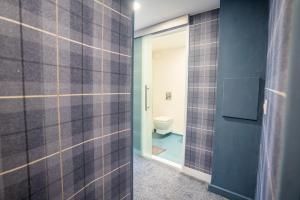 a bathroom with a toilet and a glass door at Apartment Chinatown 301 in Newcastle upon Tyne