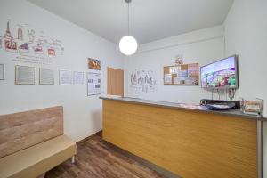 Habitación con encimera, TV y banco. en Hostel Orange, en Praga