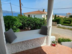 a white bench sitting on the porch of a house at Apartament Port de la Selva in Port de la Selva