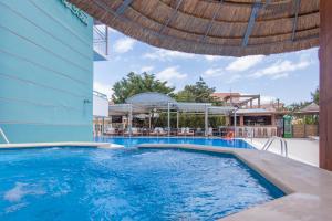 a swimming pool at a resort with an umbrella at BEL AIR HOTEL in Nydri