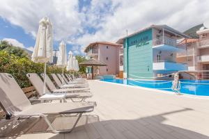 a row of chaise lounge chairs next to a swimming pool at BEL AIR HOTEL in Nydri +32 photos