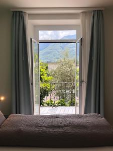 um quarto com uma cama e uma porta de vidro deslizante em Hotel Garni dei fiori em Ascona