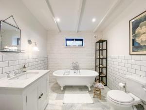 La salle de bains est pourvue d'une baignoire, d'un lavabo et de toilettes. dans l'établissement Spring House, Aldeburgh A luxurious place to stay, à Aldeburgh