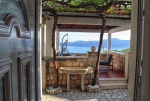 een open deur naar een patio met uitzicht op de oceaan bij Trsteno Dream House in Trsteno
