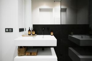 a bathroom with a white sink and a mirror at Apartamenty Oliwia - Kącik in Krakow