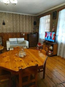 sala de estar con mesa de madera y TV en Guest House-Waterfall en Chokhuldi