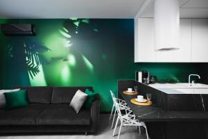a living room with a couch and a green wall at Apartamenty Oliwia - Kącik in Krakow