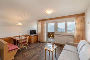 a living room with a couch and a table at Pension Grafenau in Schenna