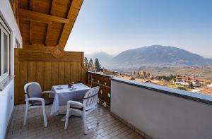 a table and chairs on a balcony with a view at Pension Grafenau in Schenna