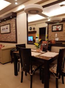 a dining room with a table and chairs and a couch at Sarasota Residential Resort cluster 4 Unit 6C & 6L by Manny Newport Blvd, across NAIA T3 & near Resorts World Manila, Pasay City in Manila