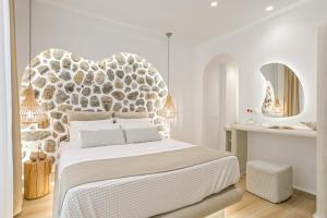 a white bedroom with a large bed and a mirror at Villa Adriana Hotel in Agios Prokopios