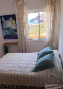 蓋博德帕洛斯的住宿－Cala Reona Holiday Apartment，一间卧室配有一张带窗户的床