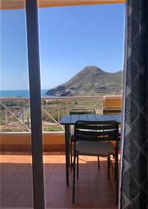 un tavolo e sedie su un balcone con vista sull'oceano di Cala Reona Holiday Apartment a Cabo de Palos
