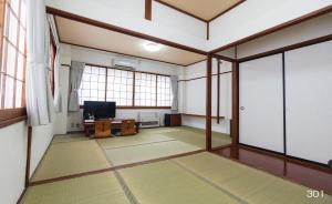 VOYAN Resort Fujiyamanakako Gekkoso في ياماناكاكو: غرفة فارغة مع نافذة كبيرة وتلفزيون