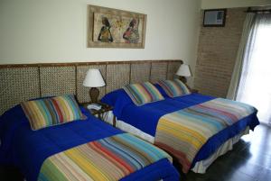 Dos camas en una habitación con sábanas azules. en Hotel Cumuruxatiba, en Cumuruxatiba