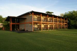Un gran edificio con césped delante. en Hotel Cumuruxatiba, en Cumuruxatiba