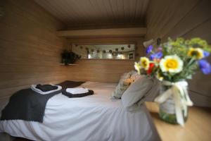 a small bed in a room with a vase of flowers at The Shepherd's Hut in Sheriff Hutton
