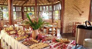 a table filled with different types of bread and pastries at Hotel Cumuruxatiba in Cumuruxatiba