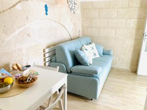 a living room with a blue couch and a table at Antigua in Monopoli +31 photos