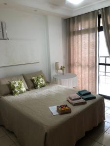 1 dormitorio con 1 cama grande y toallas. en O PARAÍSO É AQUI! Apto muito próximo a praia en Guarapari
