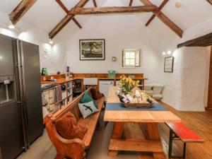 a kitchen with a wooden table and a kitchen with a refrigerator at Ty Mellen in Newport Pembrokeshire