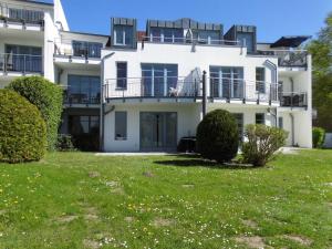una gran casa blanca con un patio verde en Appartement Residenz Bellevue Whg 42 Usedom, en Zinnowitz